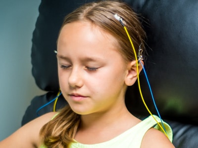 SNC - Neurofeedback-Training - Beispiel Mädchen, Augen geschlossen, Elektroden mit ZAmp verbunden